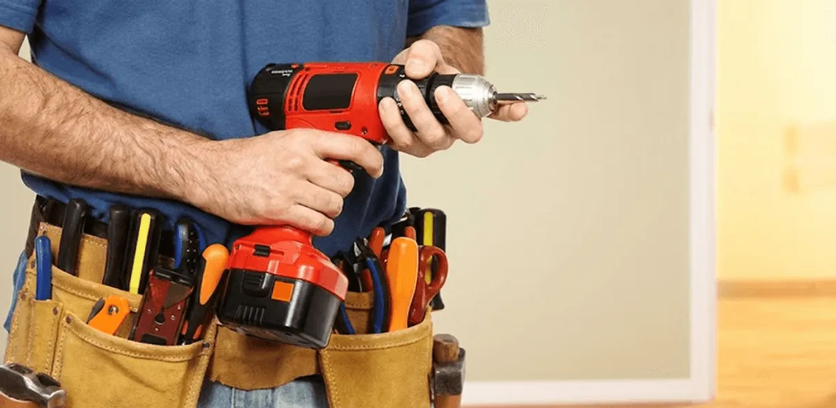Handyman holding a power drill for home repairs and installations in Lakewood, CO